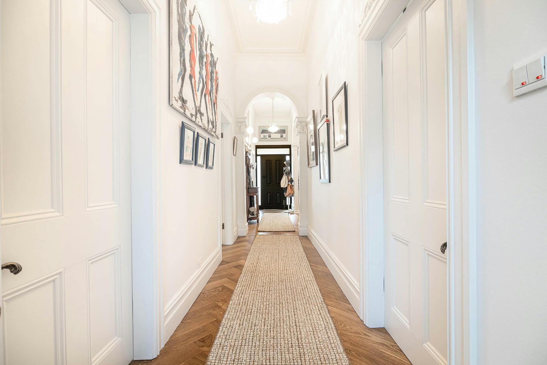 Bright, freshly painted hallway with white walls and timber flooring