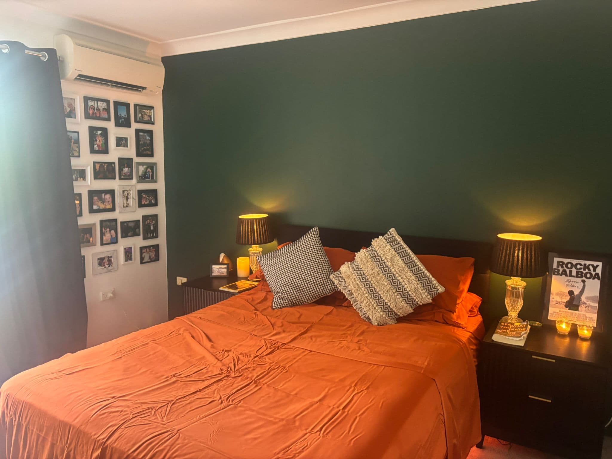 Bedroom with forest green accent wall and warm lighting